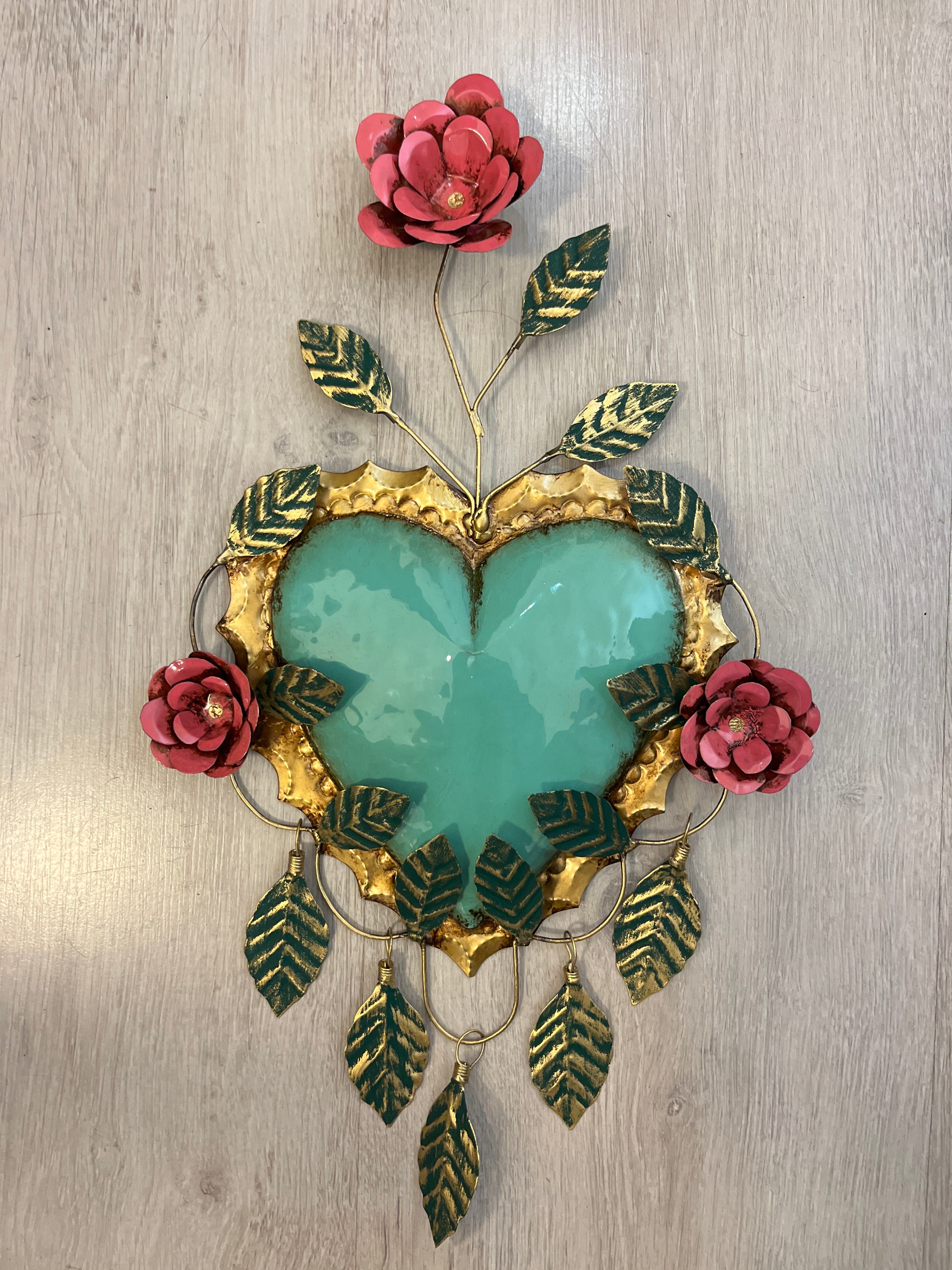 Corazón con tres flores y marco de hojas colgantes
