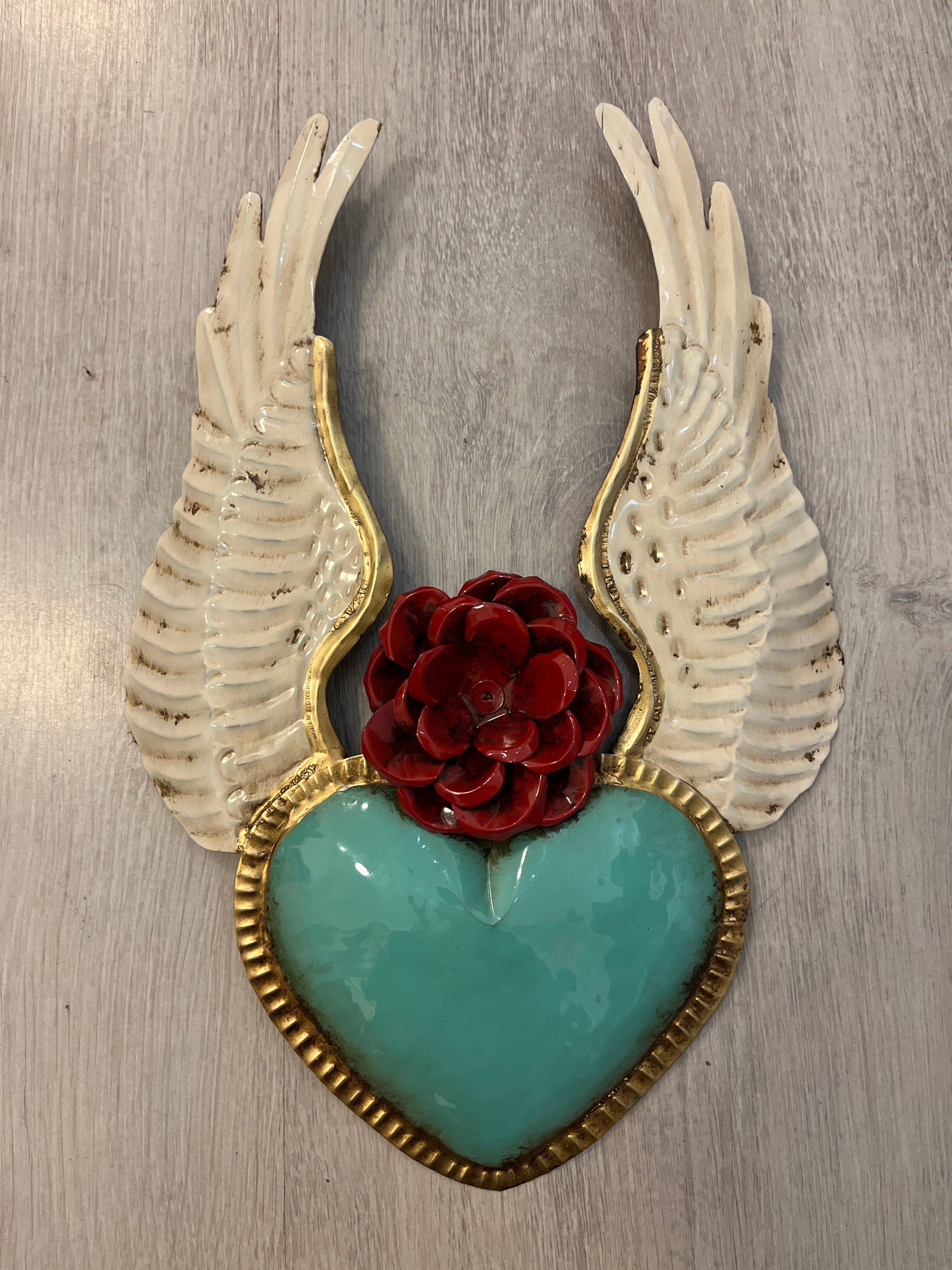 Corazón alado con una flor