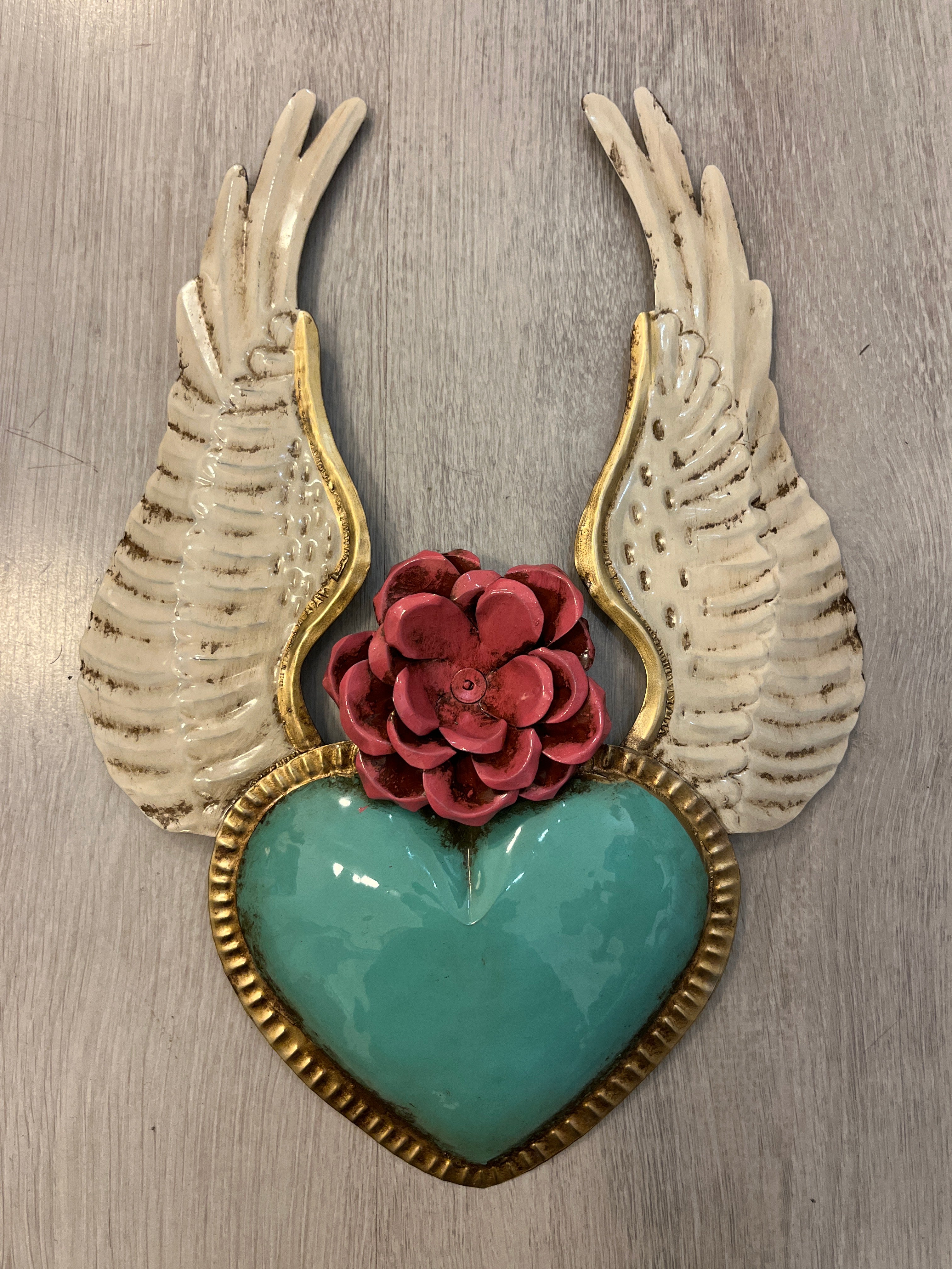 Corazón alado con una flor