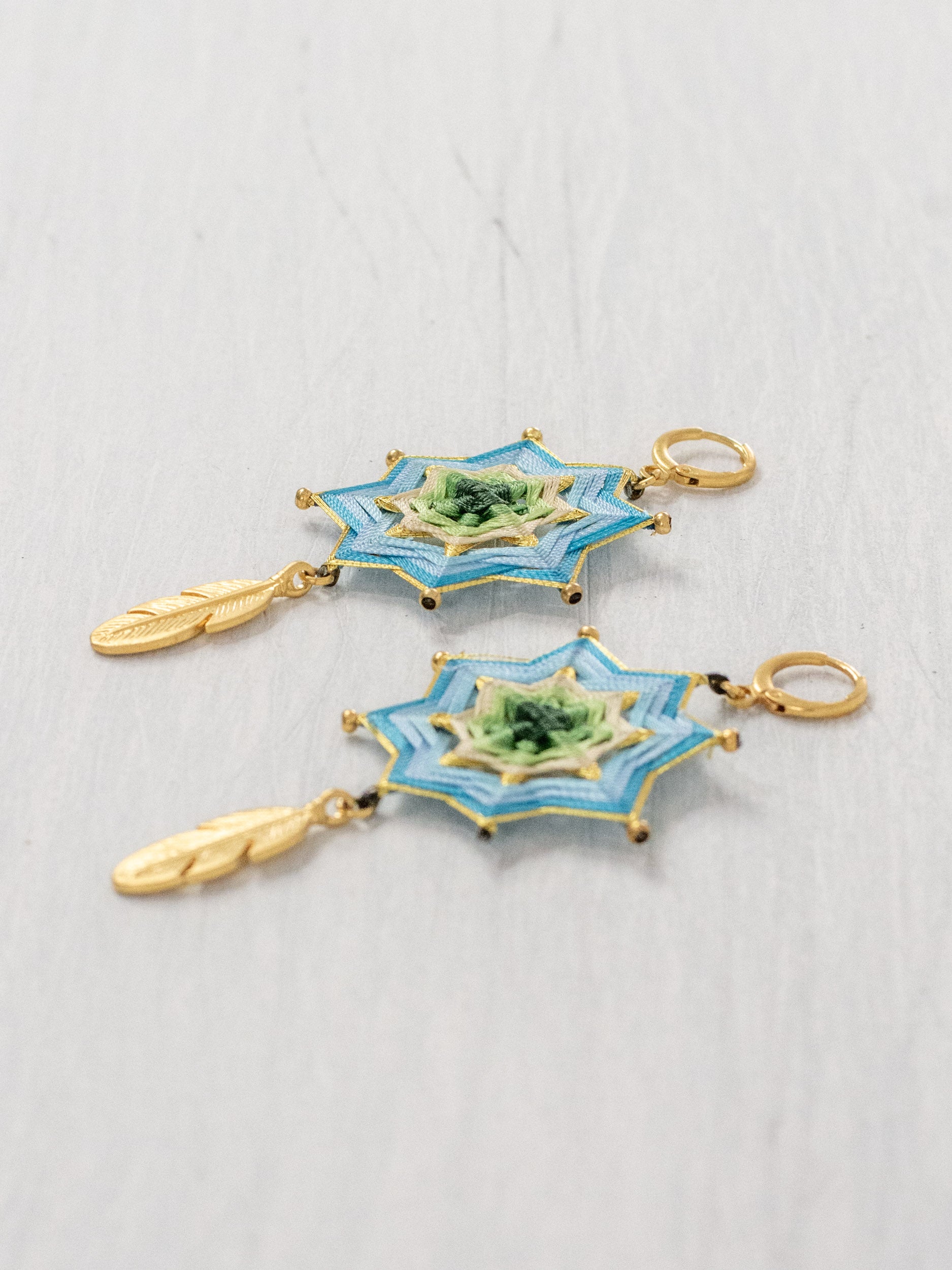 Aretes mandala estrella con plumas grandes