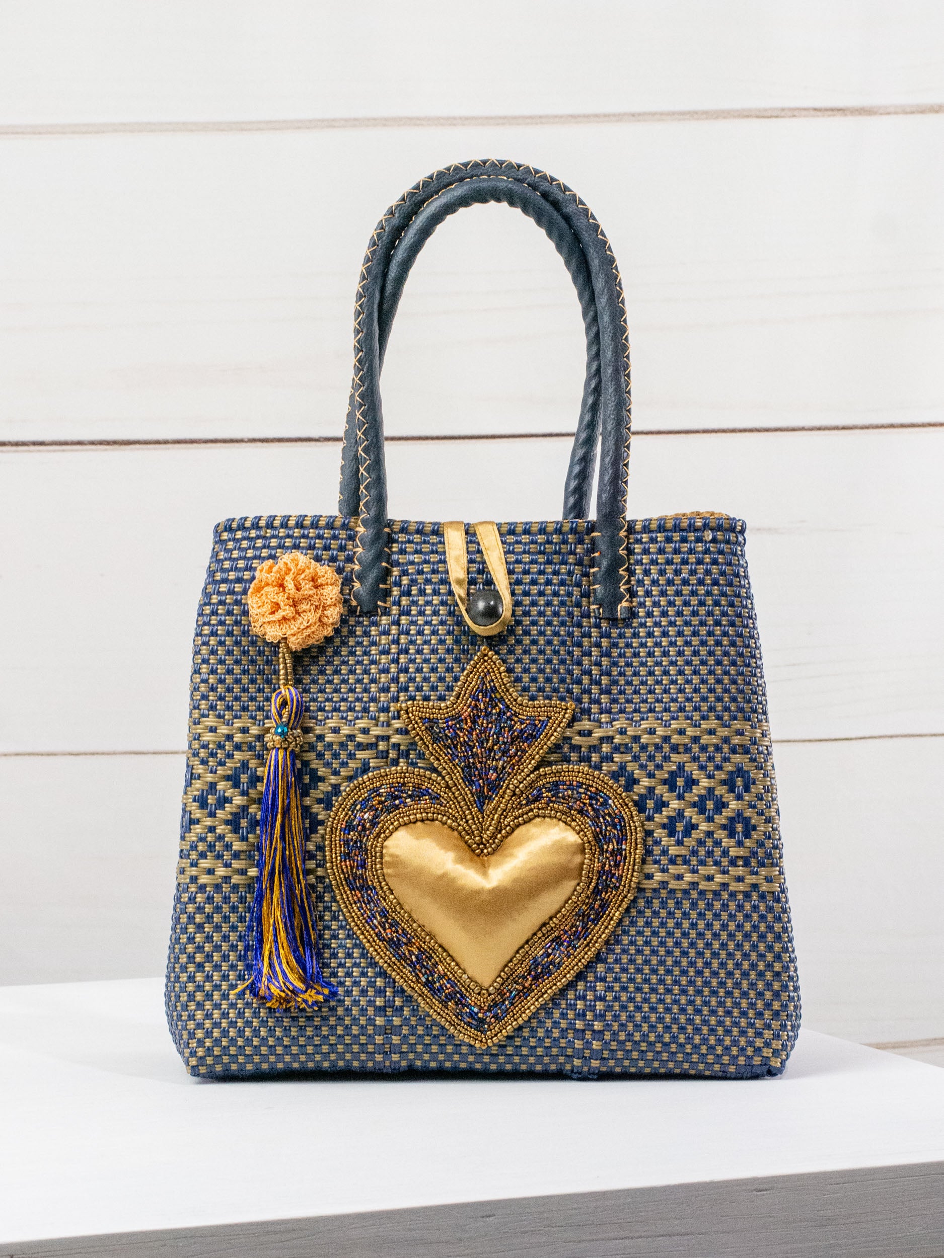 Bolsa artesanal corazón milagro mediana con pompón de flor